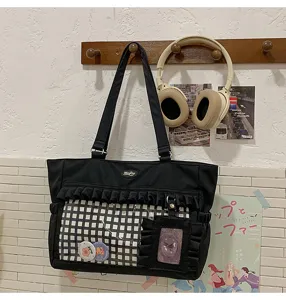 Detailansicht einer schwarzen Rüschen-Ita-Tasche mit transparentem Fenster und Karofutter