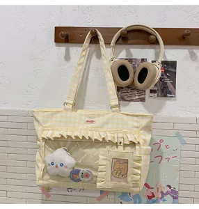 Gelbe Gingham-Ita-Tasche mit transparentem Fach und Stern-Plüschanhänger.