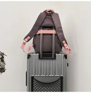 Macro view of purple backpack with pink trolley sleeve on silver suitcase handle