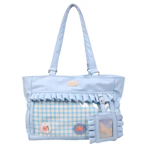 Detailansicht der hellblauen Ita-Tasche mit transparentem Fenster, Rüschen und Karomuster.