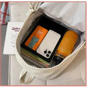 Gros plan sur la grande capacité intérieure et le motif à carreaux de ce sac à dos scolaire.