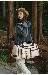 Detailed view of the large capacity beige travel bag in an outdoor hiking setting