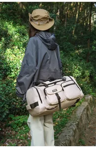 Large capacity cream travel duffel bag with multiple pockets used in outdoor forest setting
