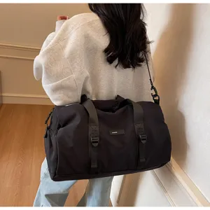 Moderne zwarte minimalistische sporttas op vrouwelijk model voor reizen en fitness