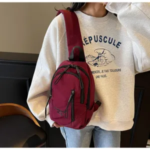 Städtische utilitaristische weinrote Umhängetasche an einem Modell im lässigen Lifestyle-Look