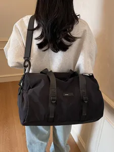 Stijlvolle minimalistische zwarte sporttas en casual reistas op de rug van een model