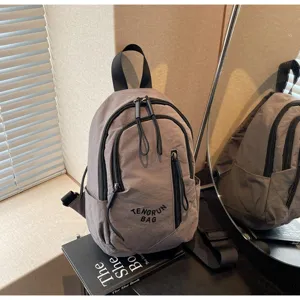 Nahaufnahme eines grauen Nylon-Minirucksacks mit besticktem TENGRUN BAG-Logo-Detail