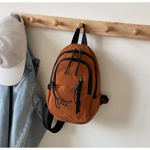 Lässige brennorange Nylon-Umhängetasche mit Doppelreißverschlüssen an Holzhaken