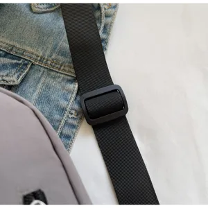 Detailaufnahme des schwarzen verstellbaren Nylon-Schultergurts mit Kunststoffschnalle.