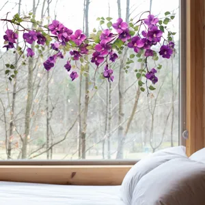 Elegant purple flower and green leaf static window decals on a bright glass pane