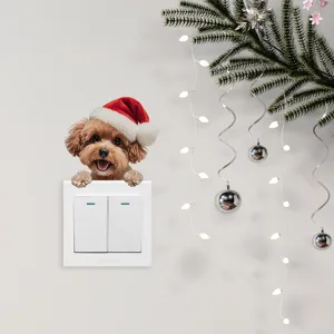 Simpatico adesivo murale 3D cucciolo di Natale che sbircia da un interruttore bianco