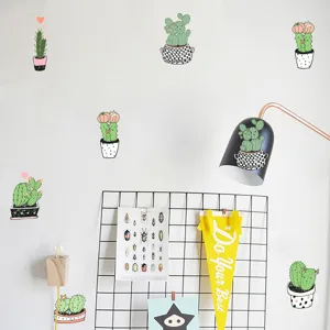 Detailed macro view of creative cartoon cactus PVC wall stickers on minimalist white wall