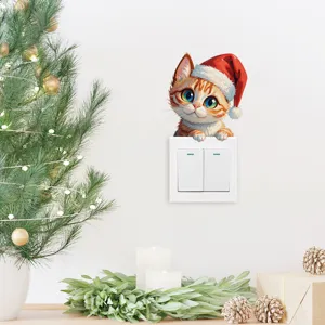 Linda pegatina de pared de gato de Navidad asomando por una placa de interruptor blanca.