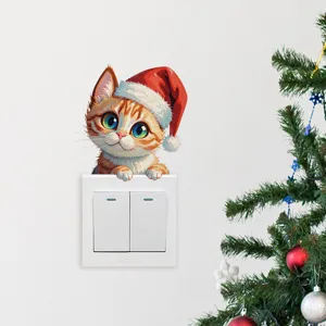 Detalle de una adorable pegatina de gato de Navidad aplicada en un interruptor blanco