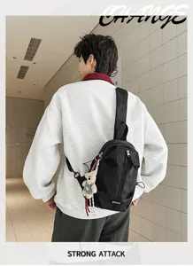 Asian male model wearing a black nylon sling bag outdoors with a cute bear keychain