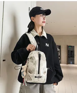 Close-up of a tie-dye marble patterned outdoor sling bag worn by an Asian female model.
