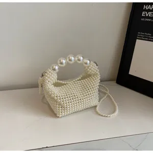 Elegante handtasche aus weißen perlen mit großem griff und langer perlenkette