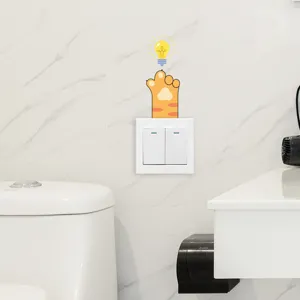 Cute cat paw and light bulb switch sticker applied on a white bathroom wall tile