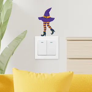Nahaufnahme eines lila Halloween-Hexe-Aufklebers auf einem weißen Lichtschalter an der Wand