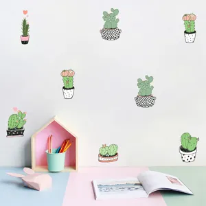 Creative cartoon cactus wall stickers displayed on a white wall above a clean desk setup