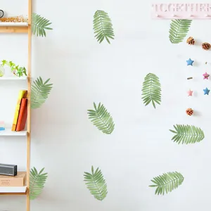 Detail showing green leaf wall stickers applied on a minimalist white living room wall