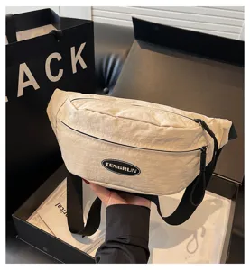 Nahaufnahme einer cremeweißen Nylon-Brusttasche mit schwarzem verstellbarem Gurt.