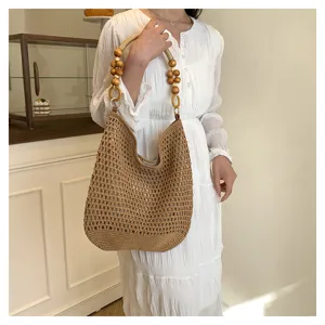 Détail d'un sac cabas en maille ajourée fait main avec anses en perles de bois