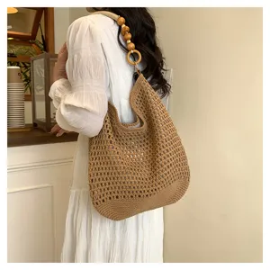 Vue détaillée d'un sac cabas en tricot marron avec une bandoulière en perles de bois