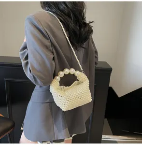 Detail der eleganten gewebten Perlen-Abendtasche mit großem Perlengriff und Kette