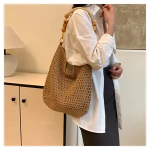 Vue détaillée d'un sac cabas ajouré tissé à la main avec poignée en perles de bois