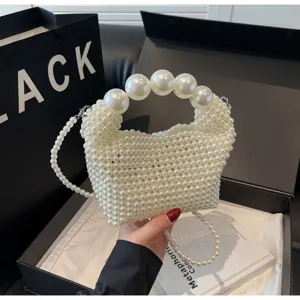Detail einer weißen Perlen-Abendtasche mit großem Perlengriff in Geschenkbox