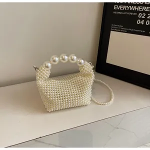 Detailansicht einer handgewebten weißen Perlen-Abendtasche mit großem Perlengriff.