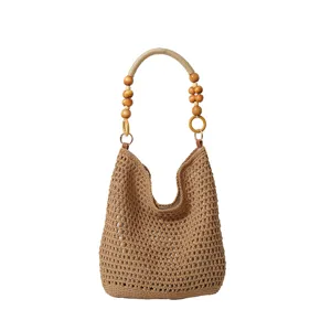 Détail du sac cabas en maille tissé à la main avec poignée décorative en perles de bois