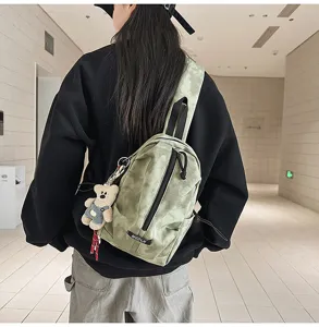 Rear view of a model wearing a green tie-dye sling bag in a minimalist interior.