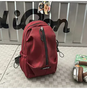 Close-up of a burgundy outdoor cycling chest bag on a gray industrial background.