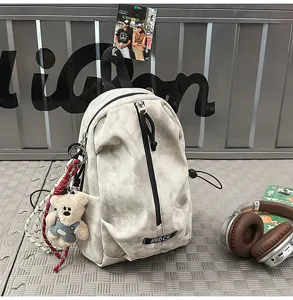 Detail of a casual tie-dye chest bag featuring a bear charm and headphones in the background
