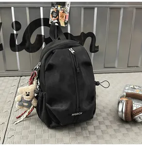 Close-up of a black outdoor leisure chest bag featuring a cute teddy bear plush charm detail