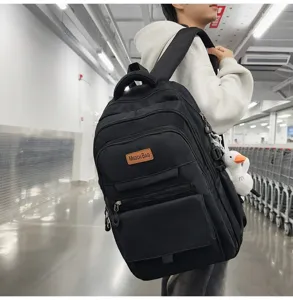 Détail de profil d'un sac à dos d'étudiant noir avec un pendentif peluche canard