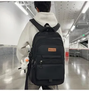 Vue arrière détaillée d'un sac à dos noir grande capacité avec un petit canard mignon