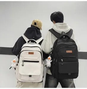Vue de dos de sacs à dos d'écolier minimalistes à grande capacité en blanc et noir.
