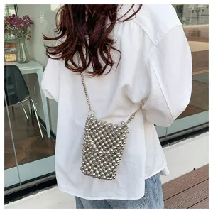 Trendy silver beaded mini crossbody bag for phone and coins, shown in a lifestyle view