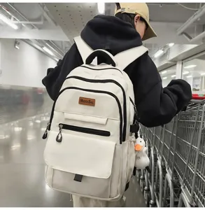 Sac à dos d'étudiant blanc grande capacité porté par un mannequin en milieu urbain