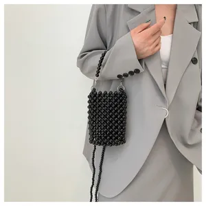Chic black beaded crossbody phone bag styled with a grey blazer for a modern look