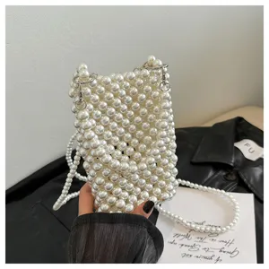 Detail view of an elegant woven white pearl phone bag with a crossbody strap