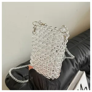 Handheld close-up showing the intricate texture of a stylish transparent beaded crossbody phone bag