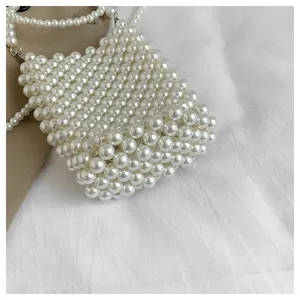 Detailed view of elegant white pearl beaded crossbody phone bag with a long shoulder strap