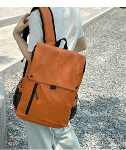 Grand sac à dos de loisirs orange et imperméable porté dans un cadre extérieur