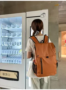 Vue lifestyle du sac à dos étanche orange porté par un mannequin en ville