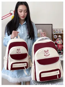 Comparison of small and large preppy color-block student backpacks with cat embroidery motif.