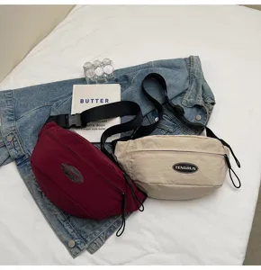 Detailansicht von lässigen Workwear-Brusttaschen in den Farben Burgund und Beige.